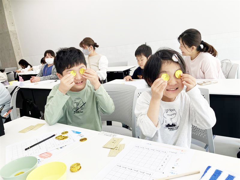 お金のコインで遊ぶ子供たち