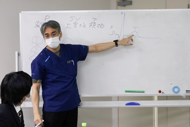 講師がホワイトボードを使って解説している様子